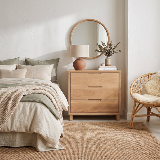 Francesca Waterfall Nightstand in a serene bedroom with a round mirror, lamp, and neutral decor.